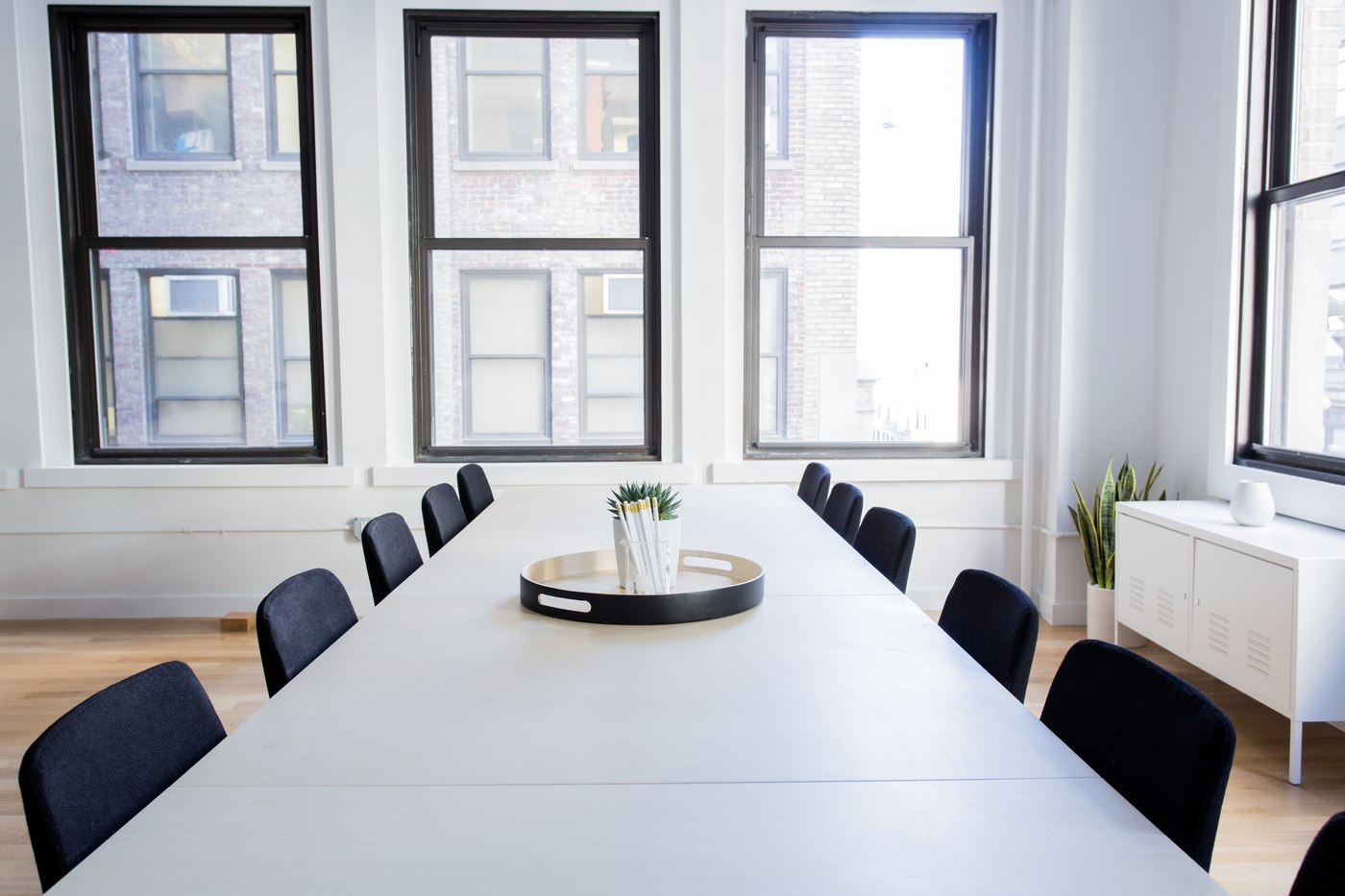 Bright minimalist boardroom with a conference table and dark chairs