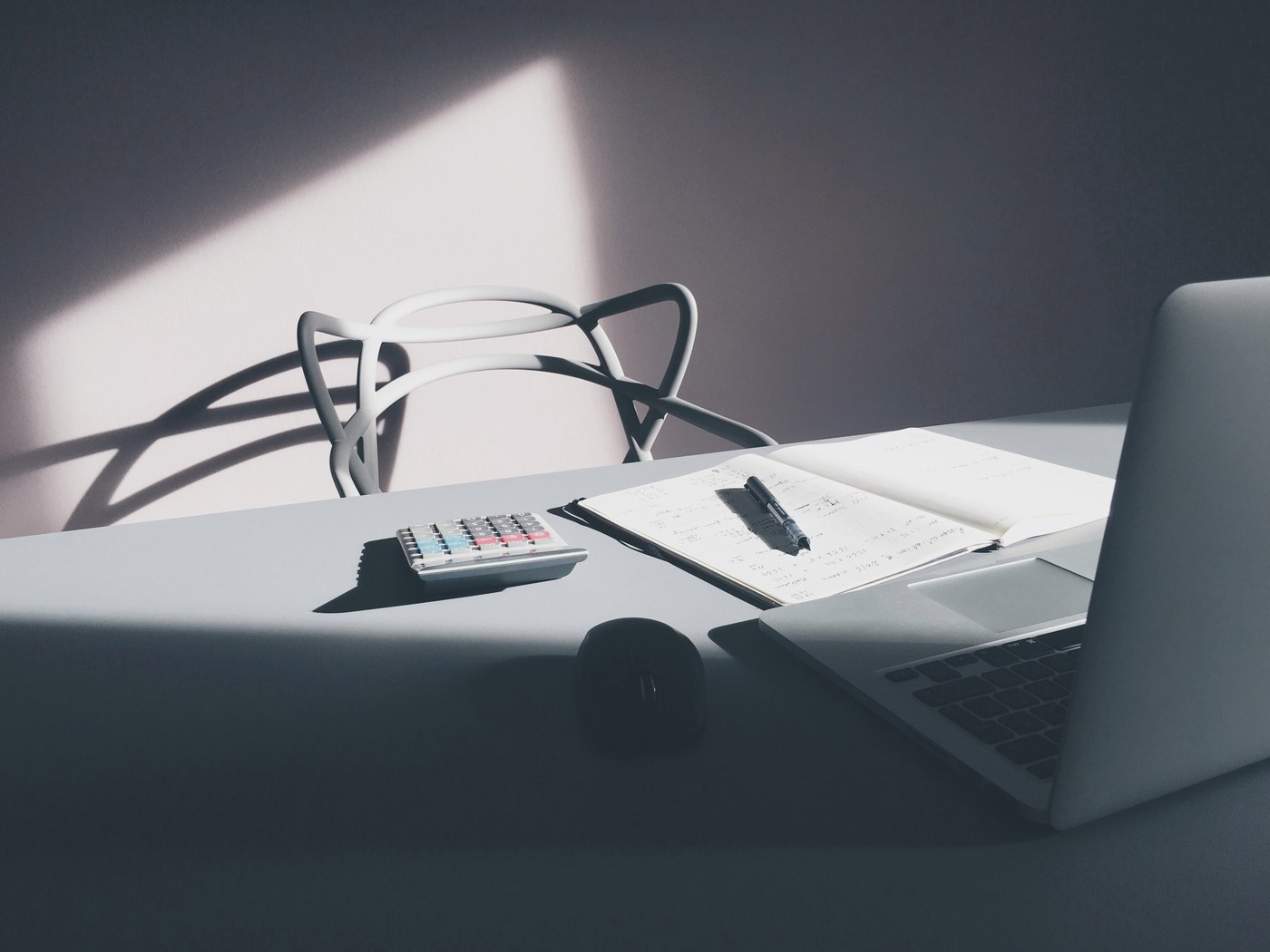 Financial planning workspace with calculator, notebook and laptop